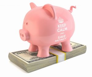 Piggy bank standing on stack of $100 bills. Bank says "Keep Calm and Save Money"